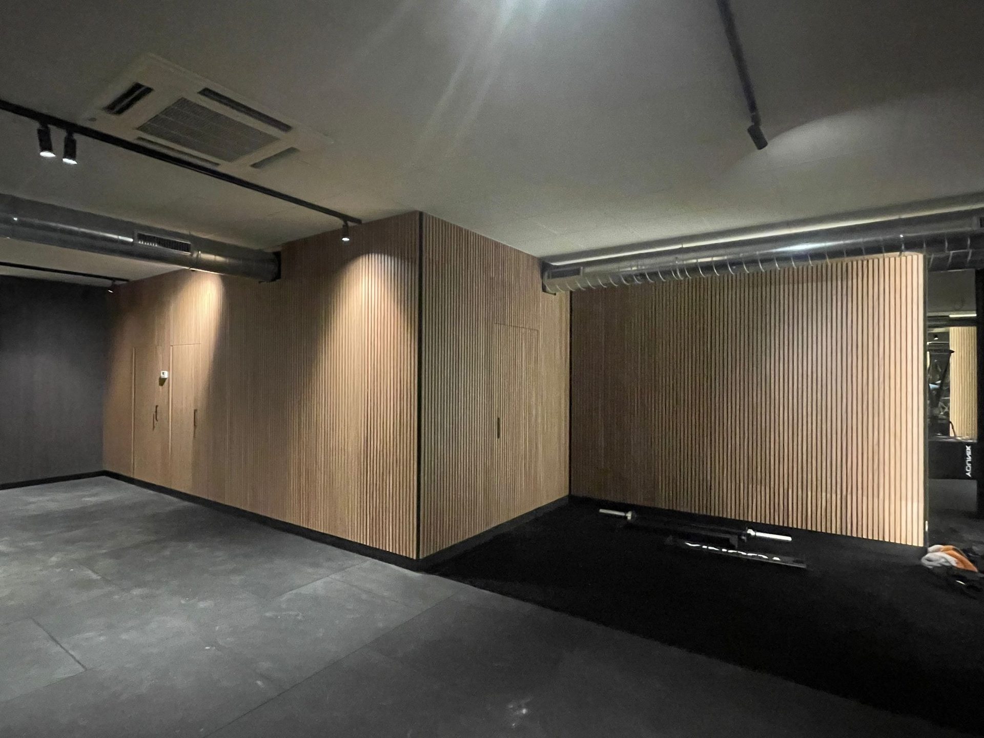 sala fitness corporativa zona vestuario listones madera oscura jpg